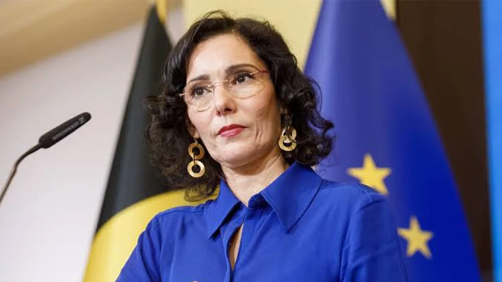 EU Commissioner Hadja Lahbib speaking at a podium during a humanitarian funding briefing.