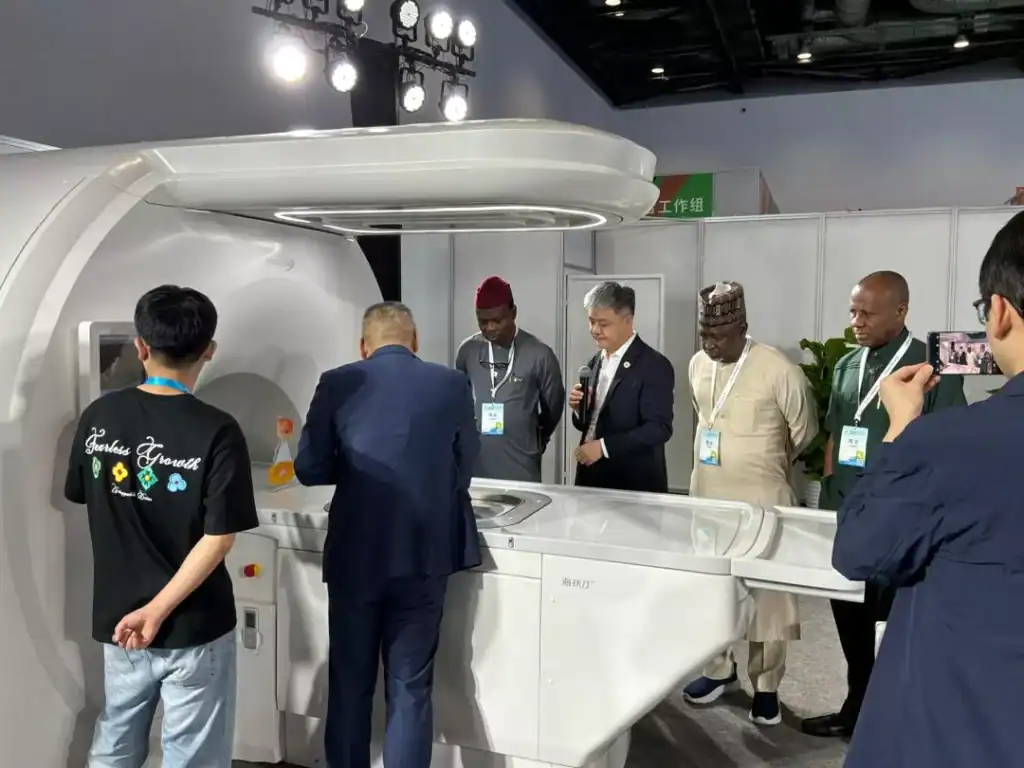 Delegates inspect medical imaging equipment at a large exhibition hall during a medical technology conference in Beijing.