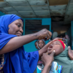 Nigeria Vaccination Campaign Targets 106 Million As Nigeria vaccination campaign targets 106 million, health worker administers oral vaccine to a child